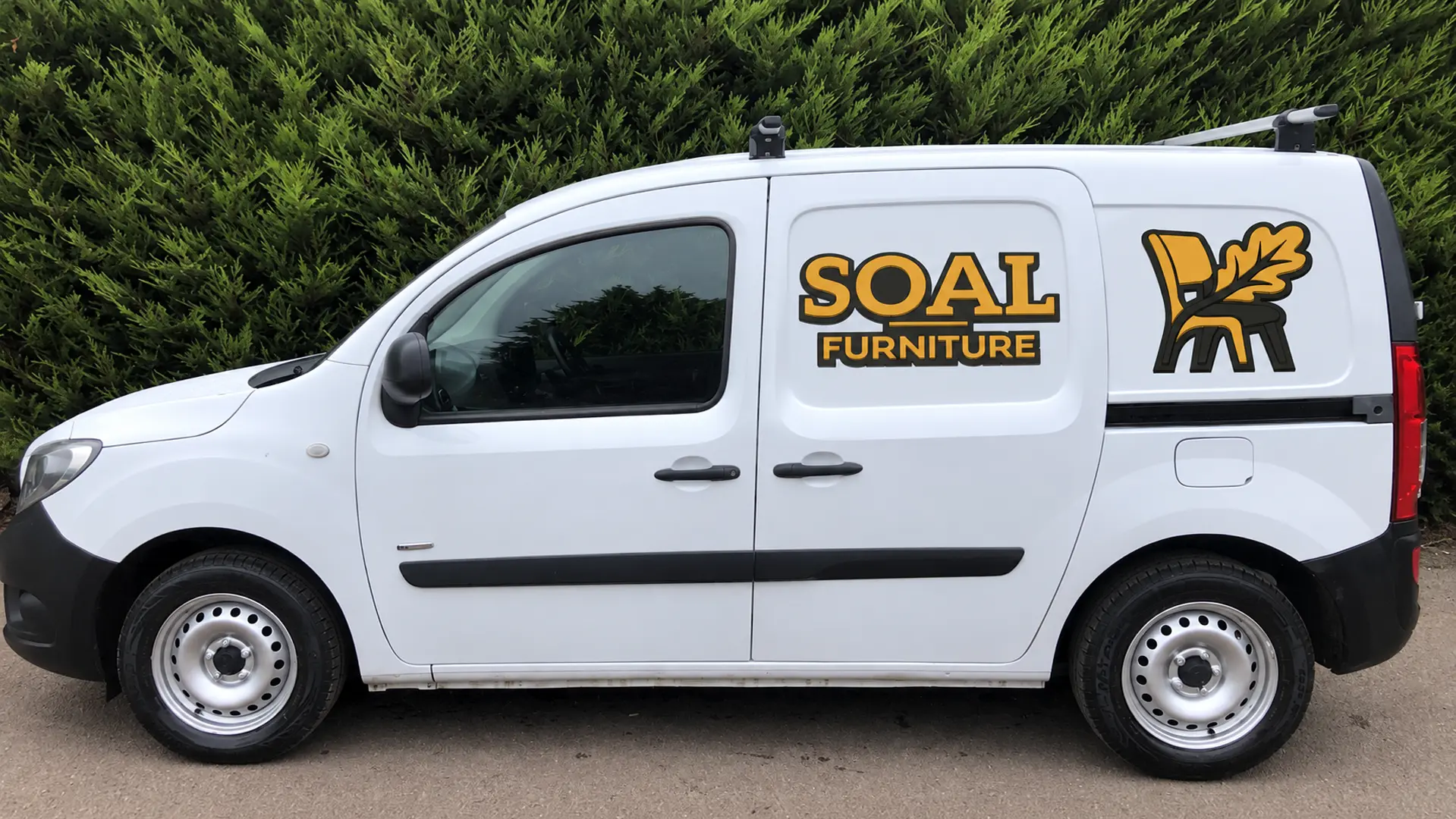 SOAL Furniture van concept mock-up showing black and gold logo and chair emblem